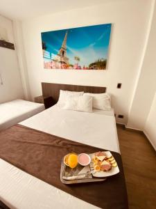 ein Hotelzimmer mit einem Tablett mit Essen auf dem Bett in der Unterkunft Jardin de Laureles in Medellín