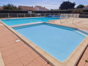 uma grande piscina com água azul em Maison Bretignolles-sur-Mer, 2 pièces, 4 personnes - FR-1-231-142 em Bretignolles-sur-Mer