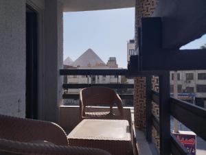 a chair on a balcony with a view of the pyramid at Zahira Pyramids View in Cairo