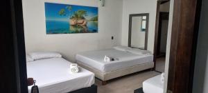 Zimmer mit 2 Betten und einem Spiegel in der Unterkunft Jardin de Laureles in Medellín