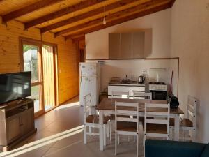 a kitchen and dining room with a table and a television at Cabaña la Tijereta del Iporá in Balneario Ipora