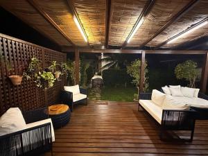 een patio met banken en stoelen op een houten terras bij Casa Buzios resort in Búzios
