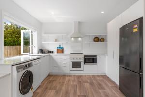 a kitchen with white cabinets and a refrigerator at Close to Town & Lake - Taupo in Taupo