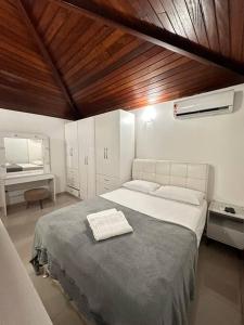 een slaapkamer met een groot bed en een bureau bij Casa Buzios resort in Búzios