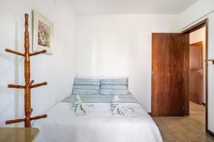 Un dormitorio con una cama con una cruz. en Apartamento a 3 min apé da praia!, en Florianópolis
