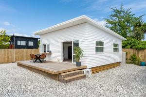 タウポにあるClose to Town & Lake - Taupoの木製デッキ付きの小さな白い家