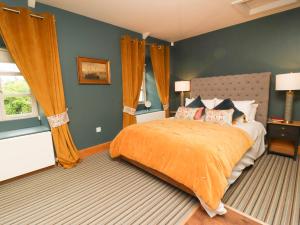 Tidal Waters في بلايموث: غرفة نوم مع سرير وبطانية برتقالية