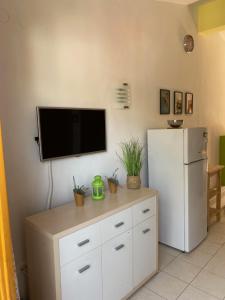 a room with a refrigerator and a tv on a wall at Apartments Lili in Baška