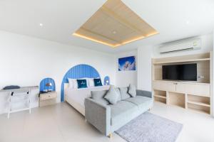 1 dormitorio con cama, sofá y TV en Costa Village Jacuzzi Bangsaray en Bang Sare