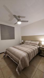 1 dormitorio con 1 cama y ventilador de techo en Acogedora Casa, en Ciudad Juárez