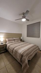Acogedora Casa في سيوداد خواريز: غرفة نوم بسرير ومروحة سقف