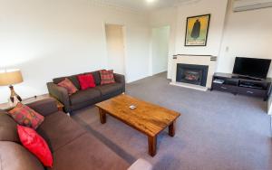 sala de estar con sofá y chimenea en Point Lonsdale Holiday Apartments, en Queenscliff