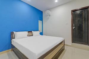 Cama en habitación con pared azul en OYO Hotel Rudra Palace Near Phoenix United Lucknow, en Charbagh