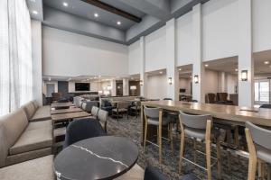 a restaurant with tables and chairs and a couch at Staybridge Suites - Dawson Creek, an IHG Hotel in Dawson Creek