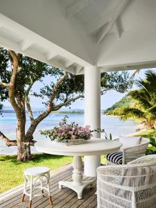 a white table on a porch with a view of the ocean at Tamarind Beach Estate in Port Vila