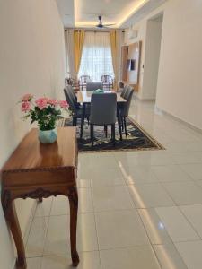 a dining room and living room with a table and chairs at Homestay Ijan in Cyberjaya