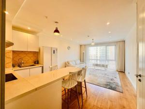 cocina con mesa y sillas y sala de estar. en City Apartment Home, en Ulán Bator
