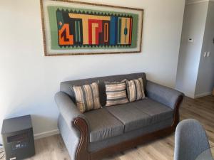 sala de estar con sofá y una foto en la pared en Agradable depa en Llanquihue, en Llanquihue