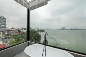 a bath tub in a room with a large window at Lakeview Residence Hotel in Hanoi