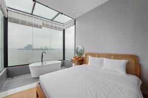 Schlafzimmer mit einem Bett, einer Badewanne und einem Fenster in der Unterkunft Lakeview Residence Hotel in Hanoi