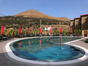 een groot zwembad met een berg op de achtergrond bij AGİOS HOTEL in Gokceada Town