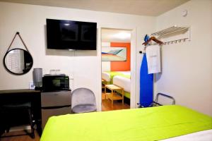 um quarto de hospital com uma cama e uma televisão na parede em City Center Motel em Medford