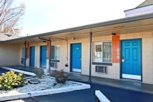 ein Gebäude mit blauen und orangefarbenen Türen darauf in der Unterkunft City Center Motel in Medford