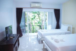 ein Hotelzimmer mit 2 Betten und einem Balkon in der Unterkunft โรงแรม ปารวี บูทีค เชียงราย (Parawee Boutique Hotel) in Chiang Rai