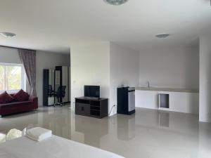 a white living room with a bed and a couch at โรงแรม ปารวี บูทีค เชียงราย (Parawee Boutique Hotel) in Chiang Rai