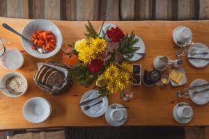 a wooden table with flowers and plates of food at Palafito Hostel Chiloé in Castro