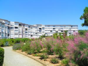 un immeuble d'appartements avec un jardin en face dans l'établissement Appartement Sète, 2 pièces, 2 personnes - FR-1-338-566, à Sète