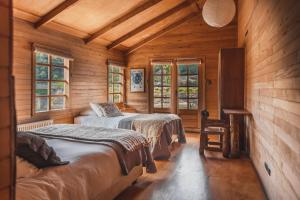 a bedroom with two beds in a wooden cabin at Palafito Hostel Chiloé in Castro