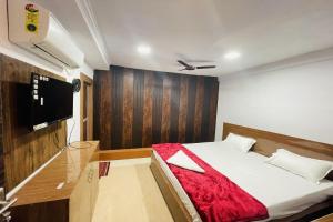 ein Schlafzimmer mit einem Bett und einem Flachbildfernseher in der Unterkunft OYO The 3 Star Hotel in Jabalpur