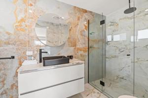 een badkamer met een wastafel en een douche bij CASSA CHEVRON ISLAND- Luxury Waterfront House in Gold Coast