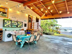 patio con mesa, sillas y lavadora en Home near Volcano National Park, Hilo, Kehena, en Keaau