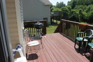 a deck with chairs and a grill on it at Safari Rooms in Concord