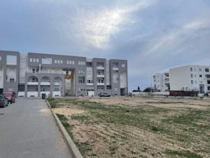 un parking vide devant un bâtiment dans l'établissement Appartement moderne, vue mer, à Harqalah