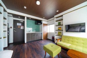 salon z żółtą kanapą i telewizorem w obiekcie Kobe Motomachi Roji Building - Vacation STAY 16197 w mieście Kobe