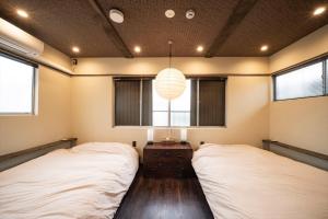 two beds in a room with two windows at Kobe Motomachi Roji Building - Vacation STAY 16197 in Kobe