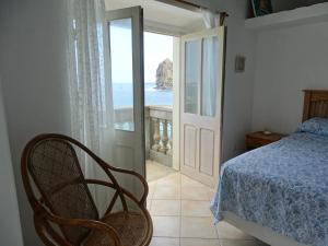 a bedroom with a bed and a view of the ocean at Sol na Baia in Vila Nova Sintra