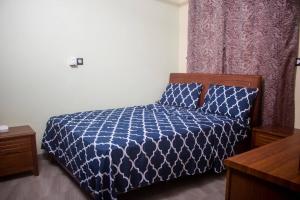 a bedroom with a blue comforter on a bed at Kadoued Furnished Apartment 2 Bedroom in Ouagadougou