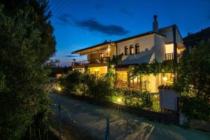 a white house with lights on a street at night at Tsamakdas House in Toroni