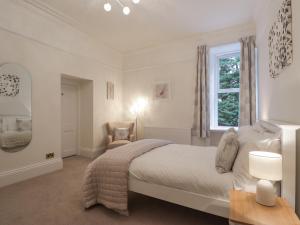 - une chambre blanche avec un lit et une fenêtre dans l'établissement Arden House, à Kingussie