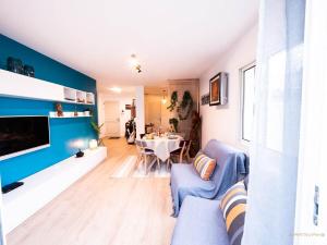 a living room with a blue accent wall at La palmeraie - Piscine vue golf in Juvignac