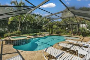 a swimming pool with white chairs and a swimming pool at Seaside Oasis 52 in Fort Myers