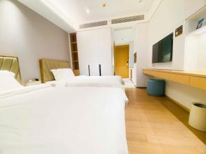 a hotel room with four beds and a flat screen tv at Rho Hotel柔居Shenzhen World Exhibition and Convention Center Qianhai Snow World in Bao'an