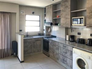 a kitchen with a washer and dryer in it at Turismo Aparts Belgrano in Buenos Aires