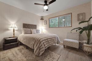 um quarto com uma cama, uma cadeira e uma janela em Álaínn Cabin in the trees em Twain Harte