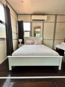 a bedroom with a white bed in a room at Katherine Farmstay Caravan Park in Katherine