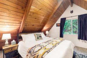 Cama en habitación con techo de madera en MACS Cushman Cabin, en Hoodsport
